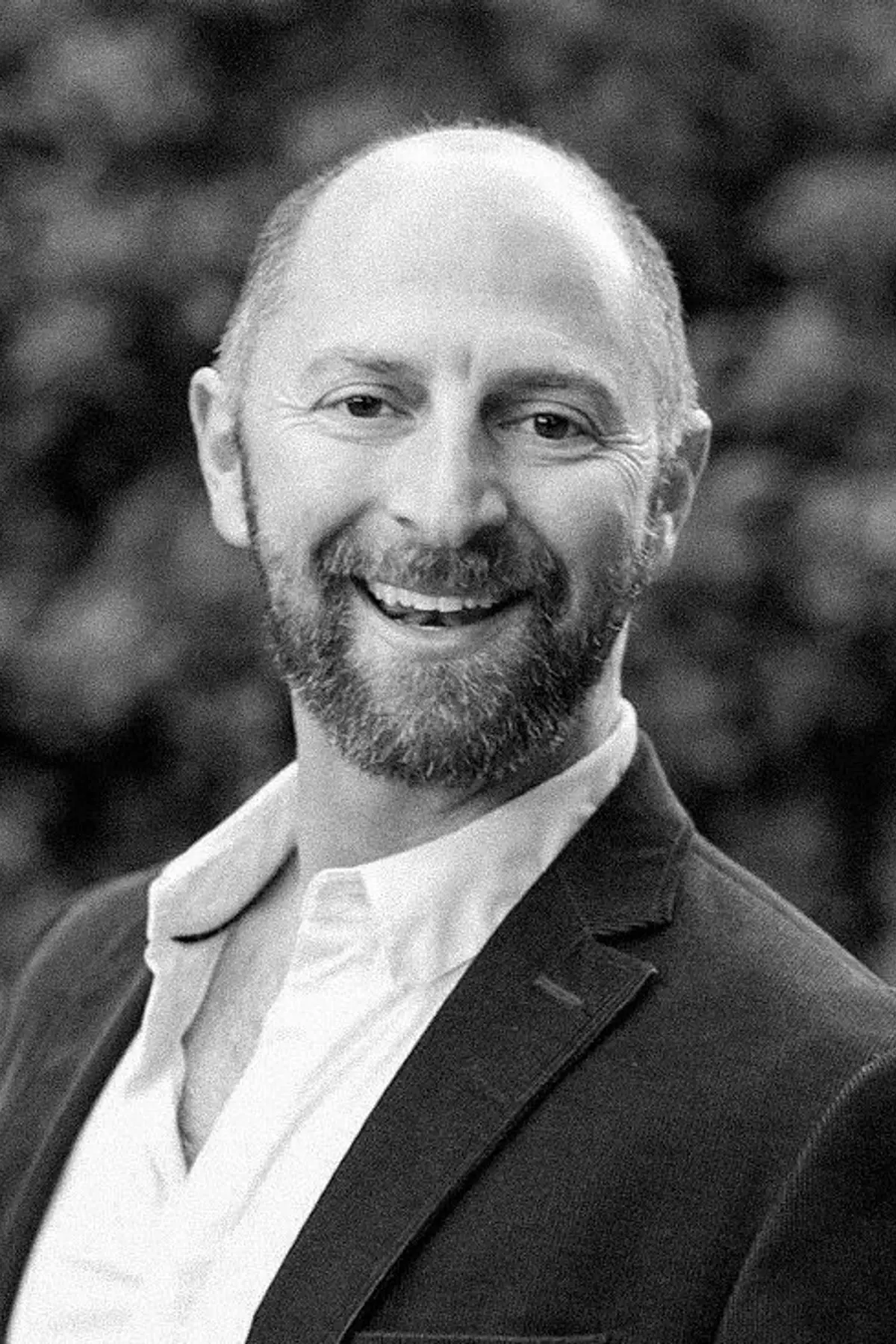 Barney Pell with a confident expression, wearing professional attire, photographed from the shoulders up in a minimalist studio setting.